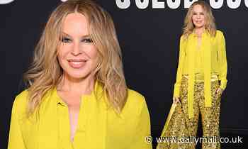 Kylie Minogue amps up the glamour in a yellow blouse and glitzy trouser suit
