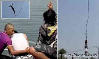 Moment tourist's bungee rope snaps, sending him plummeting into the water below and knocking him out