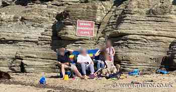 Family slammed for sunbathing underneath killer cliff face with HUGE danger sign