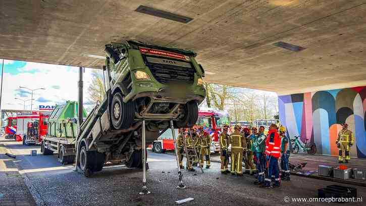 Bizar ongeval: vrachtauto klemvast onder viaduct, bestuurder gewond