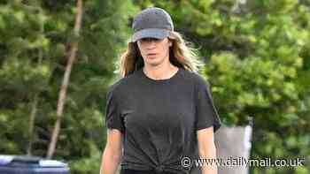 Gisele Bundchen shows off her figure in a tied-up shirt and leggings on a walk with her dog in Miami