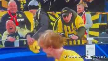 Borussia Dortmund fan appears to steal a Julian Brandt shirt from a supporter in a wheelchair after their Champions League win over Atletico Madrid... as team-mate Marius Wolf confirms they will sort the situation