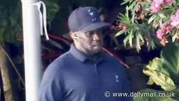 Diddy takes a call at his Miami mansion - after double raids on his homes amid sex trafficking investigation