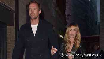 Abbey Clancy cuts a stylish figure in a sexy black dress as she links arms with towering husband Peter Crouch after attending McDonald's event