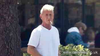 Sean Penn displays his platinum white hair as he takes a smoke break during Malibu outing