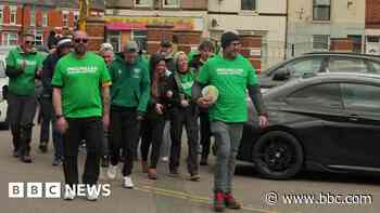 Group completes charity walk to deliver match ball