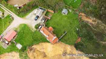 How much longer can it last? Shocking photos show £132,000 farmhouse edging ever closer to the cliff edge - as council faces race against time to demolish the property before it collapses onto the beach below
