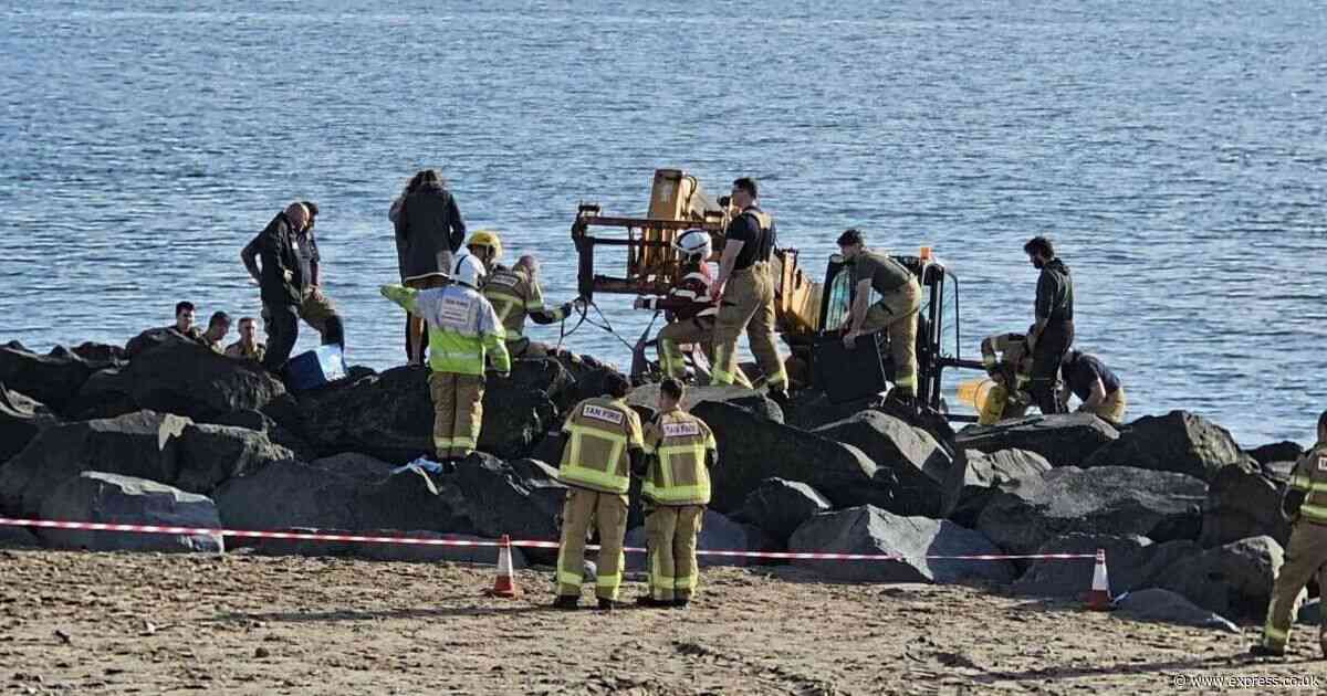 Major rescue operation with diggers to save girl stuck under rocks on beach