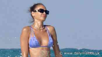 Joan Smalls flashes her washboard abs in a skimpy purple bikini as she enjoys a dip in the ocean during a fun-filled holiday in Mexico