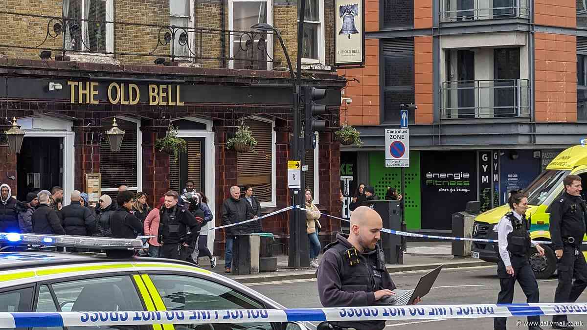 Horror after two people are stabbed on major north London high street: Woman in her 20s is rushed to hospital after knife attack - as police shut road and set up cordon outside pub