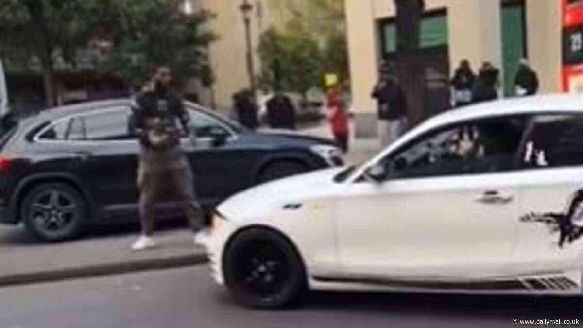 Shocking moment driver 'tries to hit cyclist with his white BMW' before attacking him with a cane after bike was thrown at his car as furious bust-up descends into lawlessness