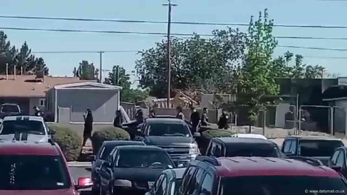 School district is on lockdown and cops swoop after pictures showed a man with a gun stalking campus