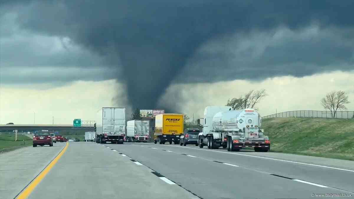 Terrifying videos show tornado sweeping across Nebraska town as eerie siren sounds...with second clip showing twister tearing across freeway and overturning machinery