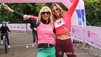 Trinny Woodall flashes her abs in a pink top as she throws her arms in the air after completing The Lady Garden Foundation Family Challenge