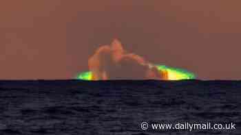 Creepy green flash lights up the sky as the sun sets over the ocean - as witnesses brand it 'paranormal'