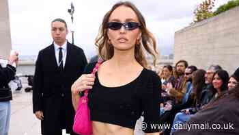 Lily-Rose Depp flaunts her washboard abs in a black crop top and pink mini skirt as she poses at the Chanel Cruise show in Marseille