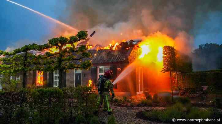 Huis met rieten dak volledig in brand, bewoners op tijd naar buiten