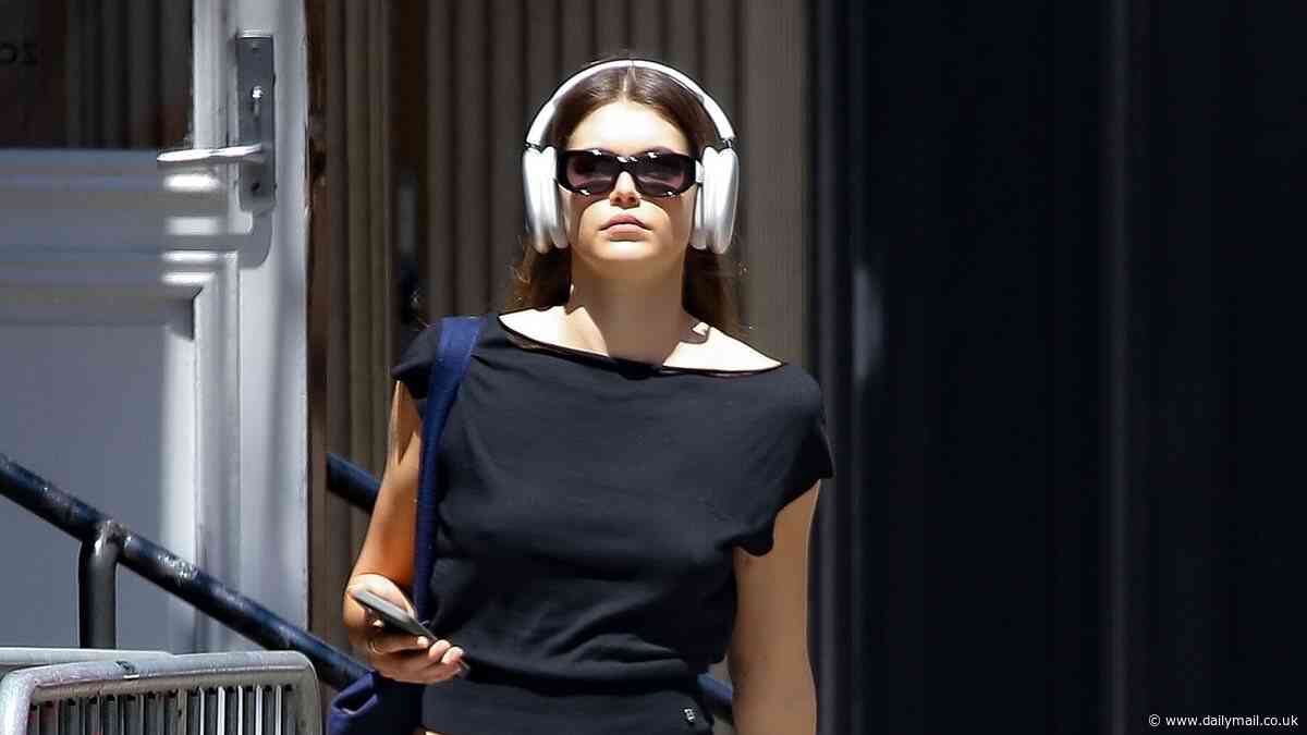 Kaia Gerber flashes a hint of her taut tummy in a T-shirt as she keeps her headphones on while in New York City... after Austin Butler date