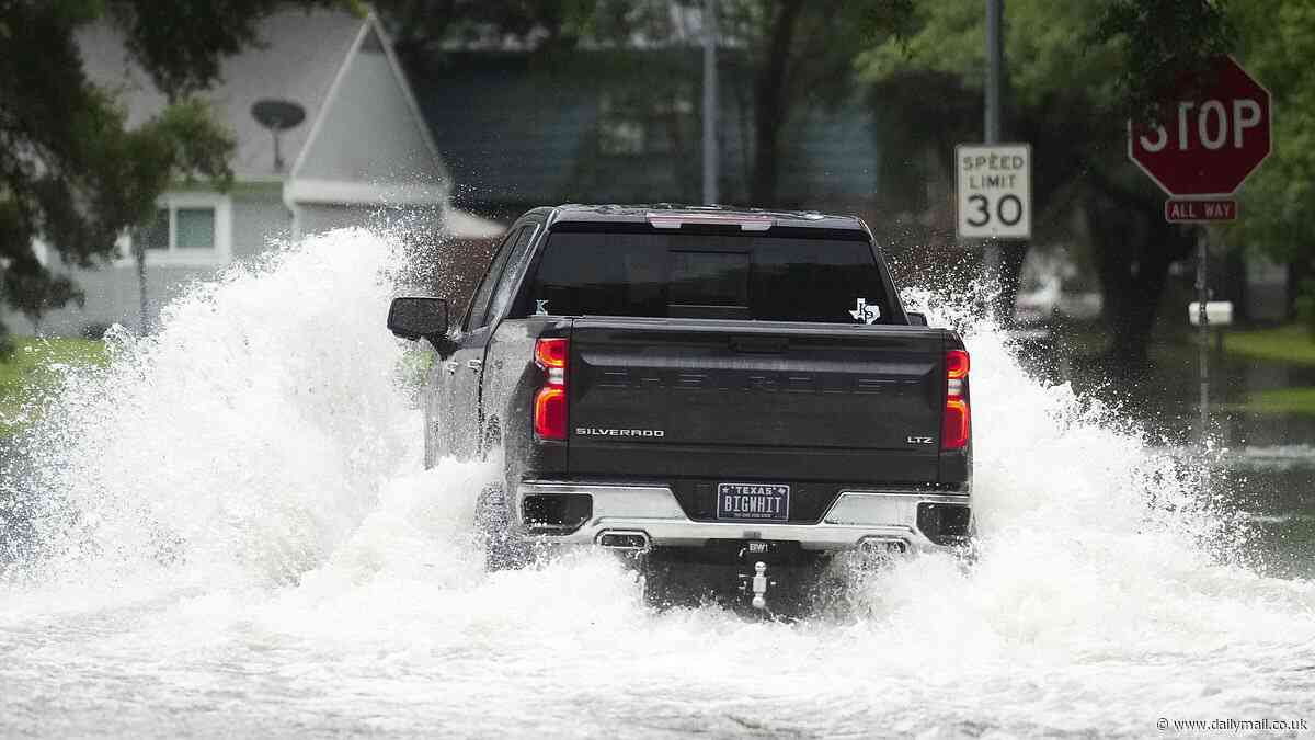 Terrifying moment truck driver scrambles out sinking vehicle as flooded Texas is battered by more rain and hail - with rivers reaching record levels and residents urged to evacuate
