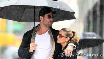 Chris Hemsworth plays the hero as he holds an umbrella to keep wife Elsa Pataky dry on stroll through rainy New York City ahead of the Met Gala