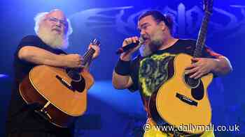 Jack Black gets a helping hand with his ponytail as he breaks a sweat on stage during Tenacious D Manchester tour date with bandmate Kyle Gass