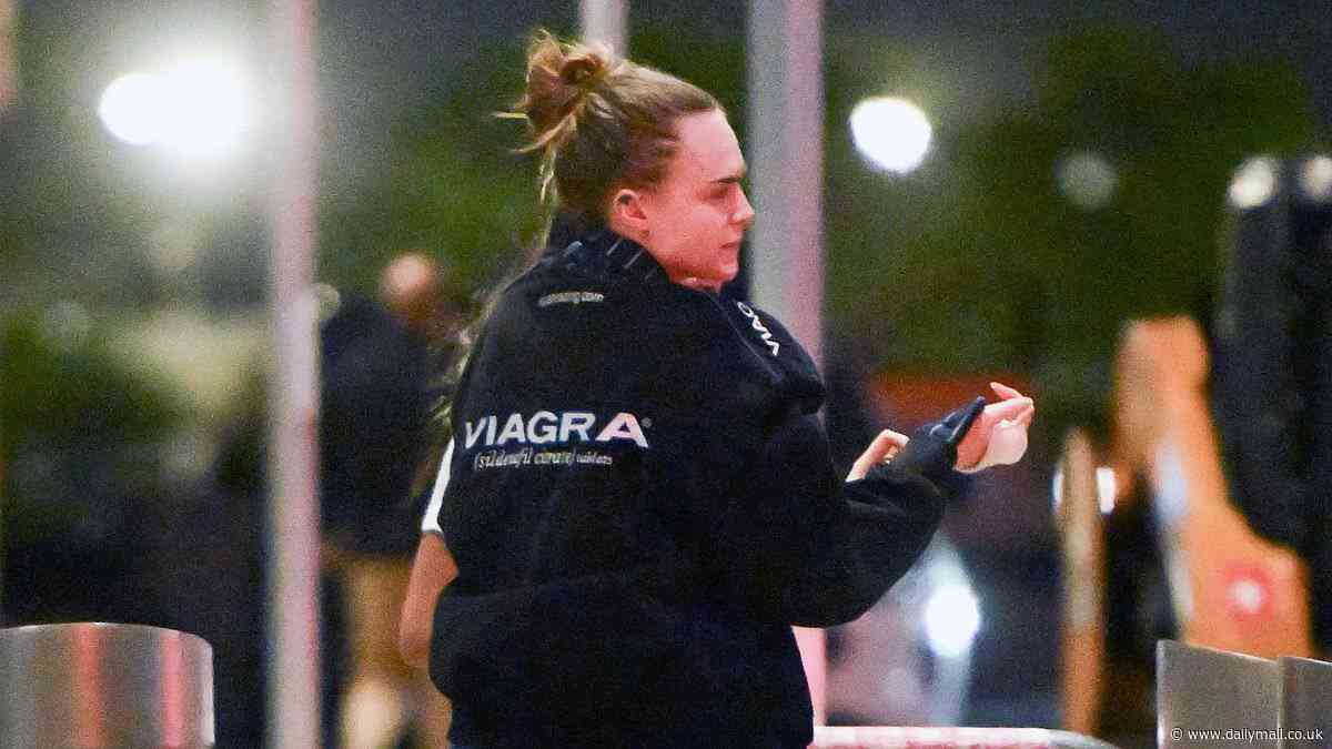 Cara Delevingne keeps it casual in white t-shirt and Viagra racing jacket at JFK airport... after clapping back at critics of her eyebrow-raising Met Gala interview