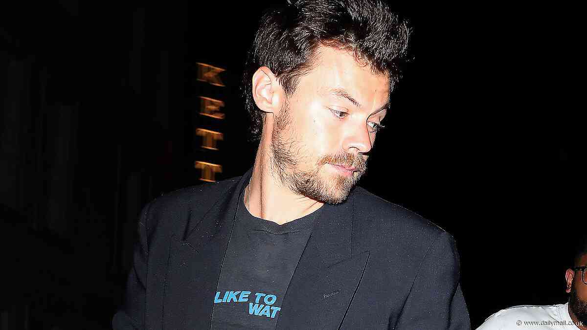 Harry Styles shows off his rugged beard and sports a voyeuristic slogan T-shirt as he departs swanky eatery in London