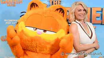 Hannah Waddingham looks chic in a white two-piece as she playfully poses with Garfield: The Movie mascot