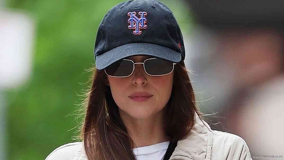 Dakota Johnson dons a Mets cap and sunglasses with a beige coat as she films Materialists in NYC