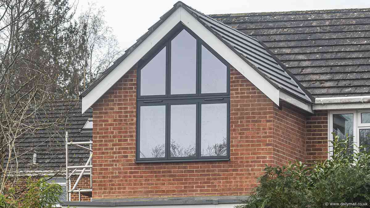 Pain in the glass! Neighbours at war after couple builds 10ft 'church' window that looks right into bedroom of family next door as furious locals blast 'monstrosity'
