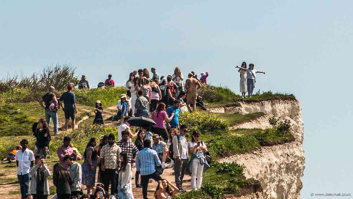More reckless idiots dice with death on the edge of Birling Gap as dozens of sunseekers crowd perilously close to the crumbling cliff face