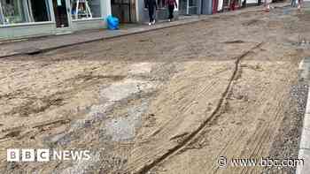 Flash flood rips up road and leaves it 'like beach'