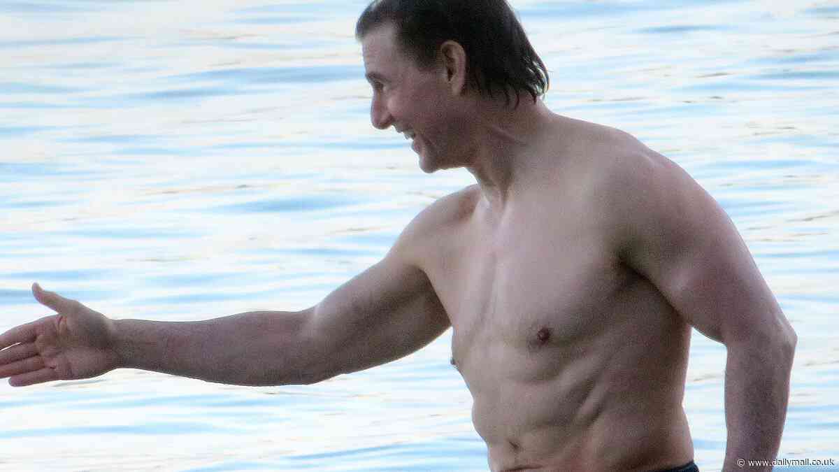 Tom Cruise, 61, shows off his shirtless physique in swimming trunks in Majorca after sporting 'dad style' socks and trainers - 40 years after stripping off for Top Gun