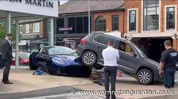 Driver mounts bonnet of £200k Aston Martin outside Wilmslow dealership