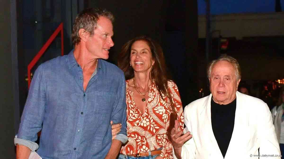 Cindy Crawford looks effortlessly chic in a floral blouse and jeans as she grabs dinner with husband Rande Gerber and a male friend