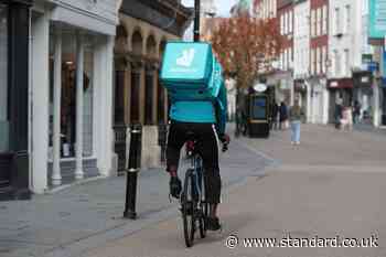 Deliveroo rider transports food on penny farthing bicycle in west London