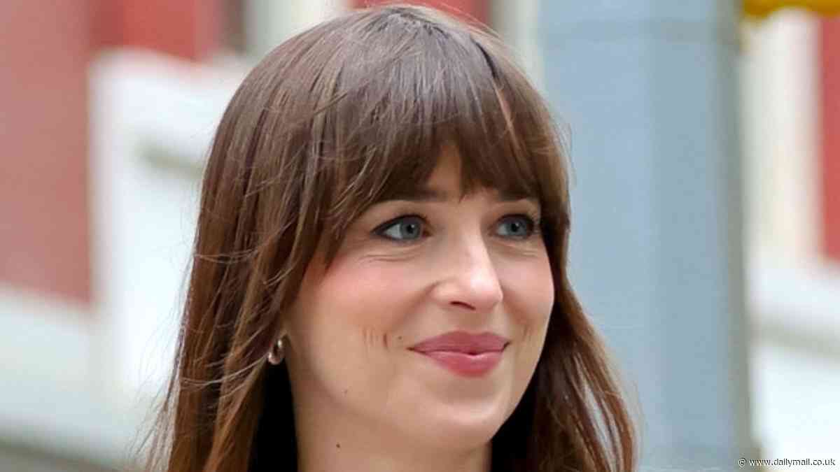 Dakota Johnson puts on a leggy display in a navy skirt suit and knee high boots as she films Materialists in NYC