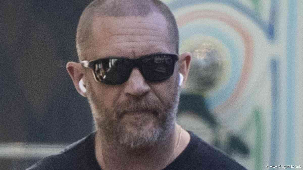 Tom Hardy shows off his newly-shaven head and toned physique as he grabs lunch in London - after photographer made bizarre claims about the set of his film Bikeriders
