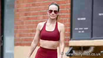 Olivia Wilde flashes her toned tummy in a burgundy sports bra and matching leggings at the gym