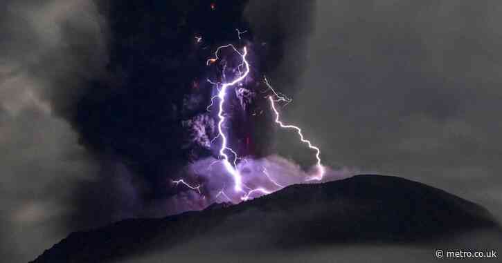 Volcano erupts as purple lightning flashes around crater in dramatic photos