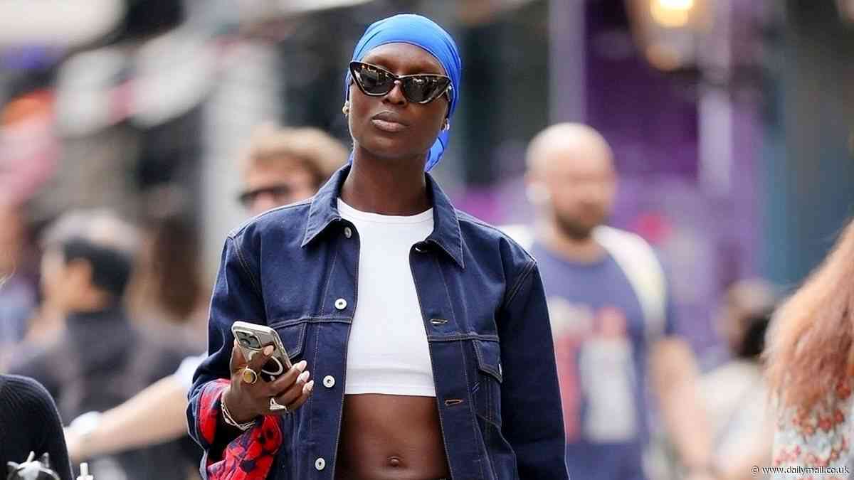 Jodie Turner-Smith flashes her washboard abs in a tiny crop top and denims as she makes her way through London carrying a huge bunch of flowers