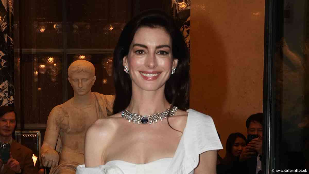 Anne Hathaway stuns in sheer white shirt dress with corset bodice and thigh-high split as she leads the stars at Bulgari Hotel in Rome