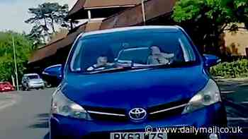 Shocking moment woman takes hold of baby while behind the wheel of a car leaves stunned eye witnesses aghast