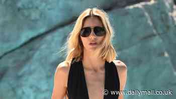 Anja Rubik shows off her model figure in a deeply plunging black swimsuit as she relaxes at the Eden Roc hotel amid Cannes Film Festival