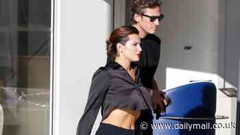 Bella Thorne flashes her washboard abs in a black crop top as she leaves Hotel Martinez with fiancé Mark Emms during the 77th Cannes Film Festival
