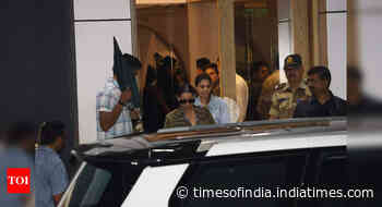SRK returns to Mumbai, shields his face under umbrella