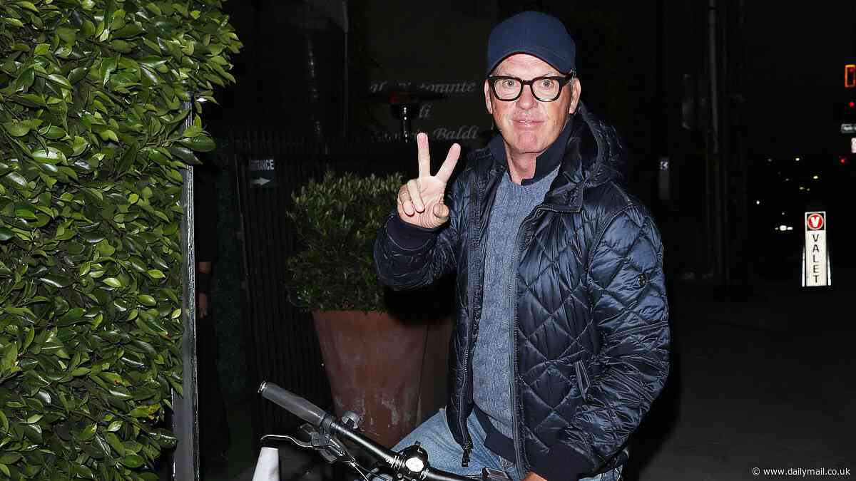 Michael Keaton, 72, and girlfriend Marni Turner, 51, coordinate in blue jeans and puffer coats as they ride bicycles to dinner in LA