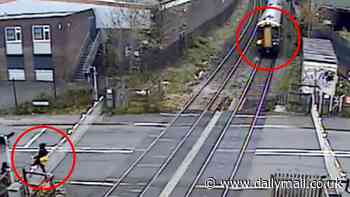 Hair raising moment man narrowly avoids being hit by a train after climbing over level crossing barrier