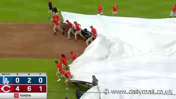Hilarious moment Reds staffer is swept up by infamous 'Tarp Monster' in Cincinnati - before having to crawl out during rain delay
