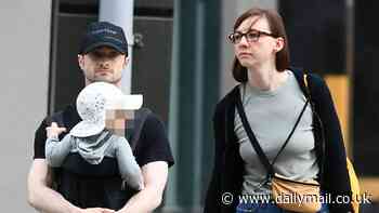 Daniel Radcliffe cradles his son, 13 months, on a family stroll with long-term partner Erin Darke in New York